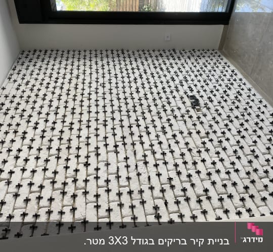 ריצוף חדש עם מרווחים ומפרידי פלסטיק שחורים